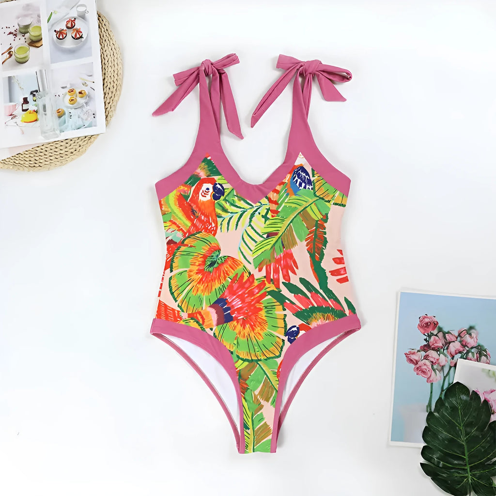 Pink floral retro one-piece swimsuit for women with V-neck and attached skirt on a hanger.