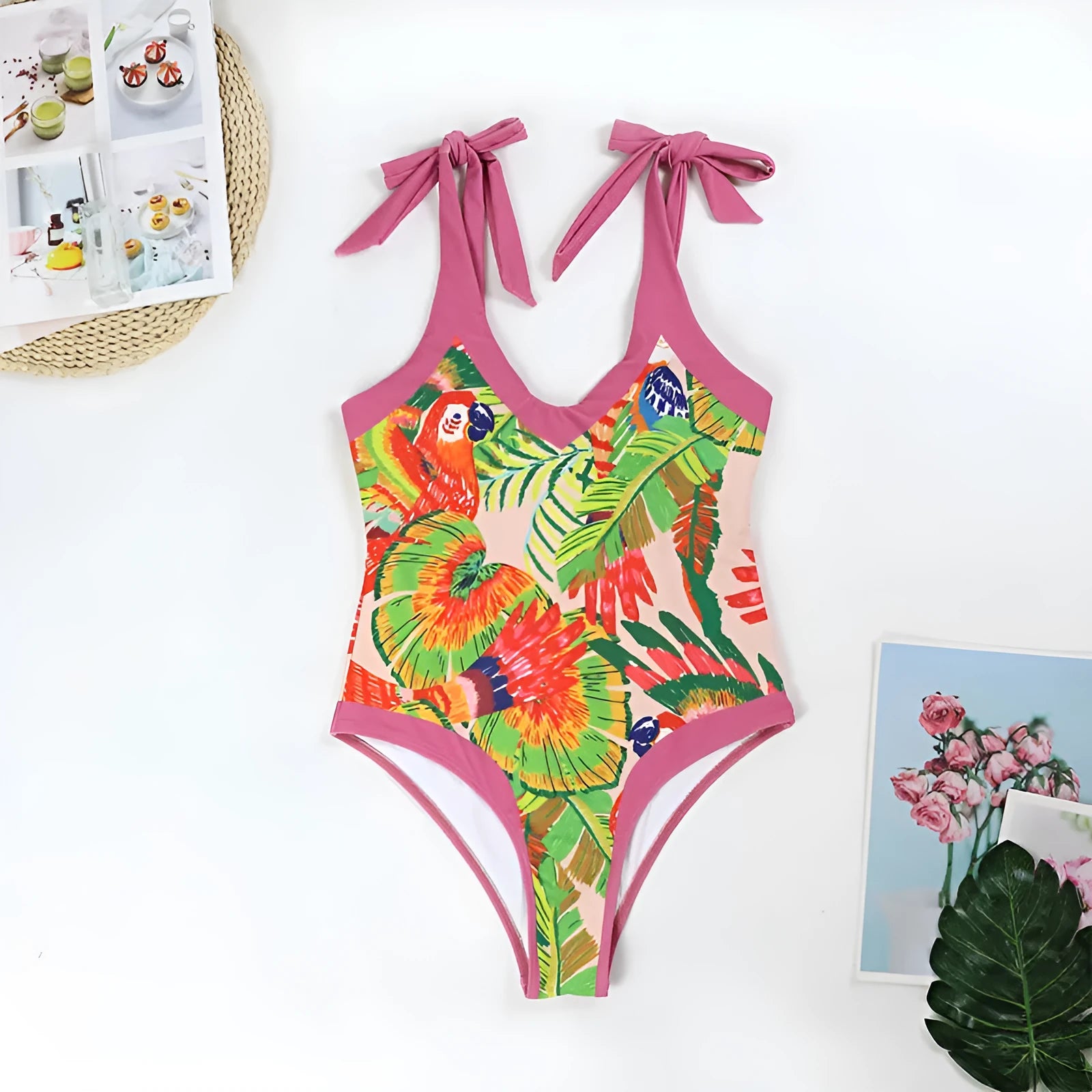 Pink floral retro one-piece swimsuit for women with V-neck and attached skirt on a hanger.