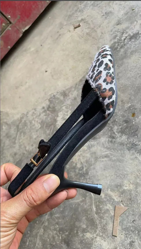 Women's leopard print suede sandals with pointed toe and high heel on size label background.