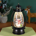 LED light-up crystal ball oil lamp Christmas ornament showing snowman or elderly figure design on a desktop.