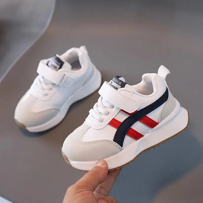 Children's white casual sneaker with Velcro fastening and rubber sole shown on size label.