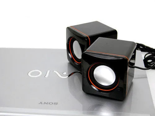 Black square USB-powered 2.0 mini desktop computer speakers on a desk