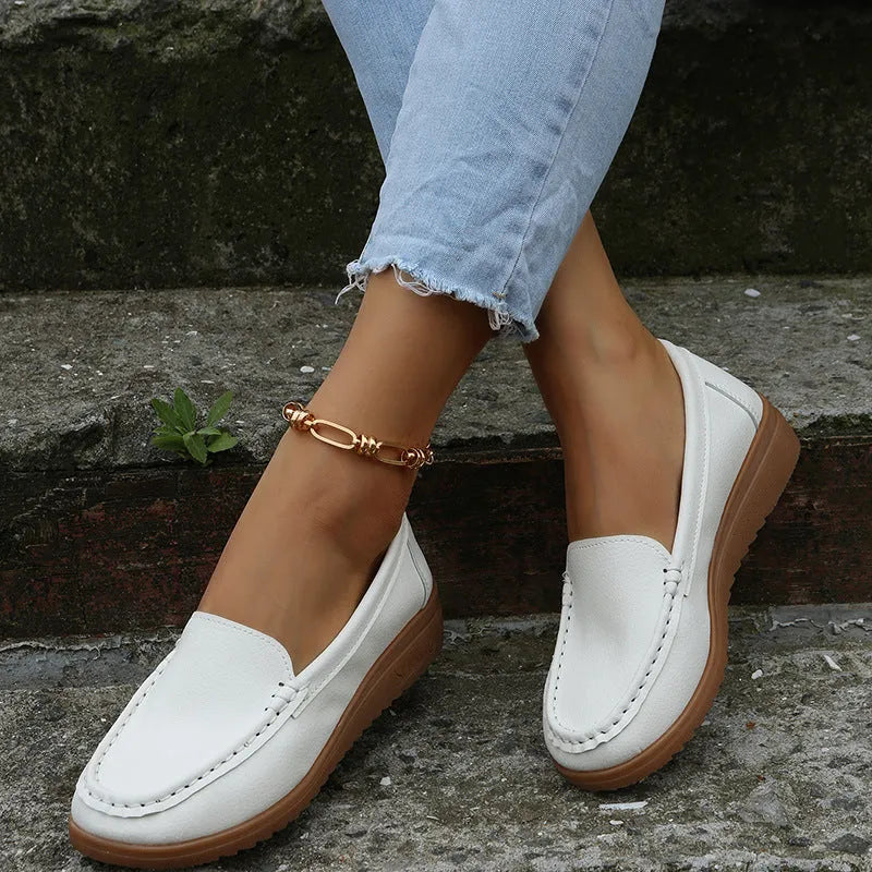 Women's flat PU leather loafers in black with round toe and car-suture detail