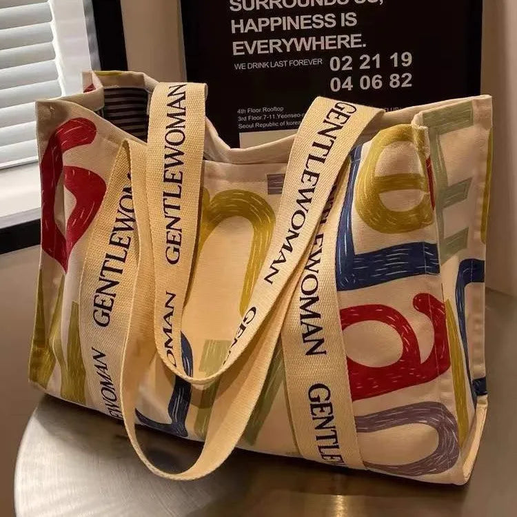 Canvas tote bag with printed design options including black letters, coloured letters, and pattern styles