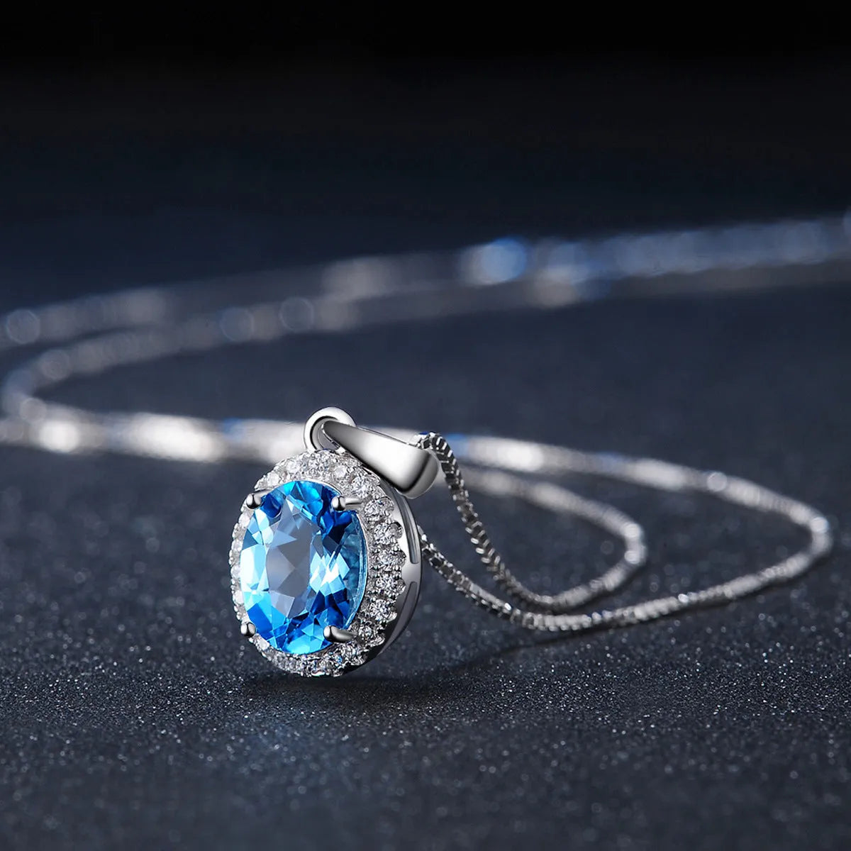 Four-piece sterling silver jewellery set with blue topaz stones: geometric earrings, ring, pendant, and necklace.
