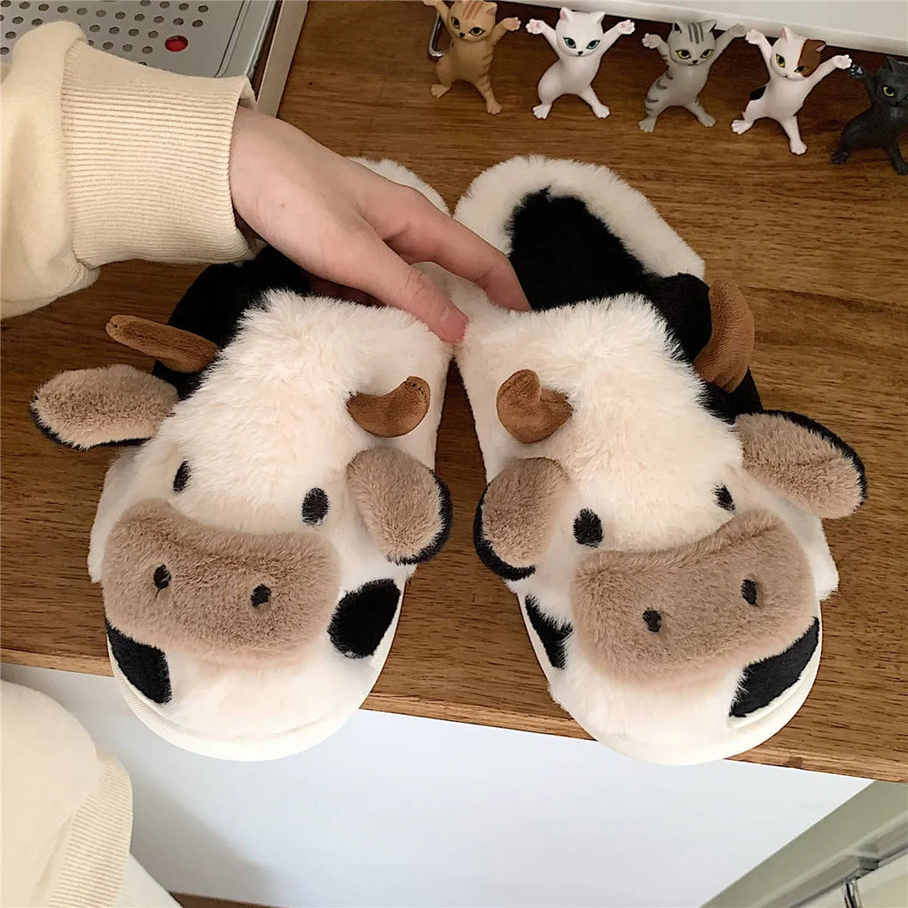 White cow-themed plush slippers for women with a non-slip textured sole.