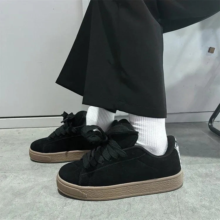 Black retro low-top sneakers for men and women on a white background, showing round toe and lace-up design.