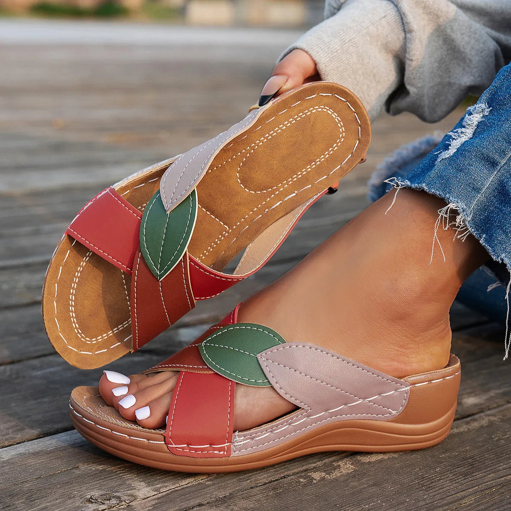 Women's black cross-strap peep-toe slippers with a thick sole, shown from the side.