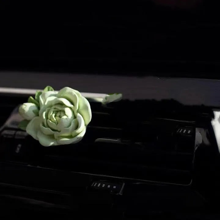 Jasmine solid car perfume gypsum tablet clipped to a car air vent.