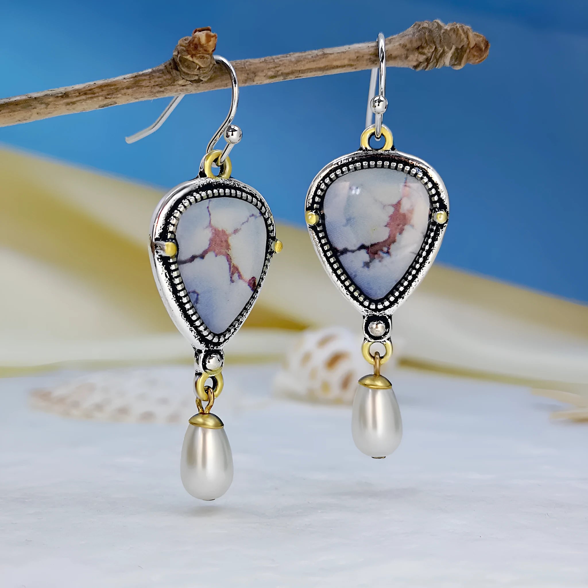 Retro blue geometric drop earrings with synthetic blue opal and white pearl on electroplated metal.