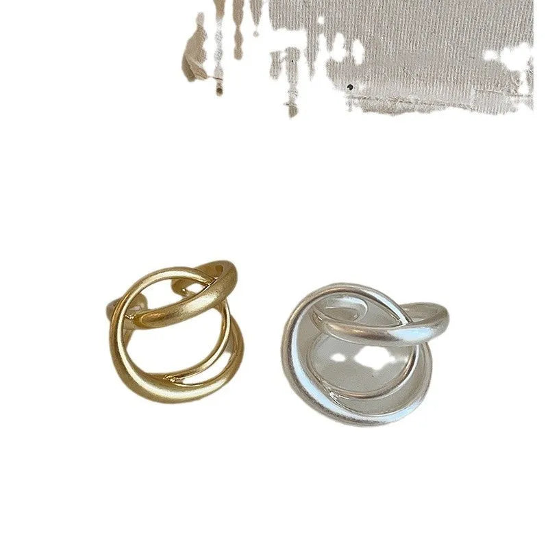 Geometric open ring with three-dimensional interlaced metal and matte electroplated finish in gold or silver colour