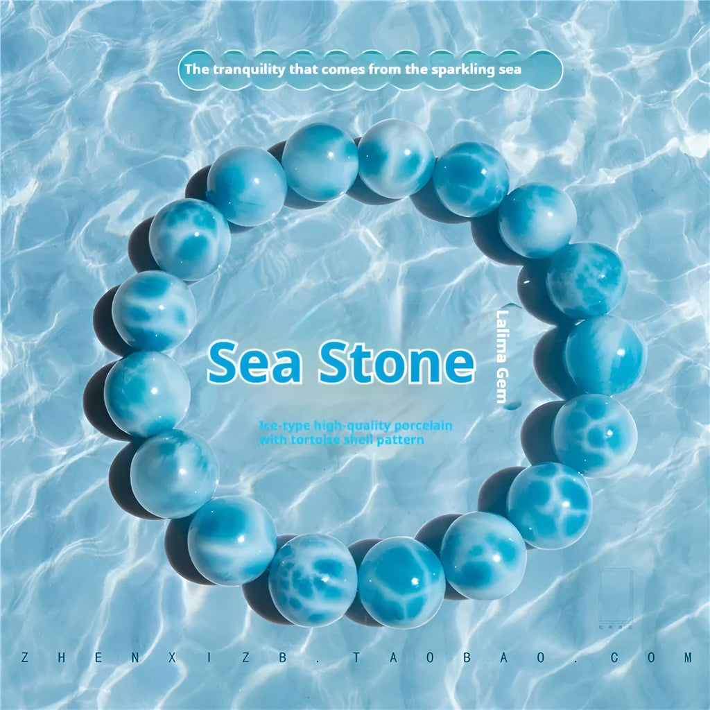 Blue handcrafted bodhi bracelet with sea-pattern crystal stones and pearl accents on a neutral background.