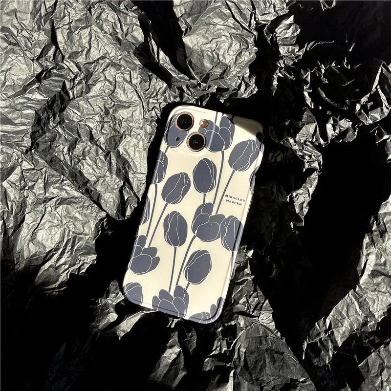 Black silicone iPhone case with a tulip pattern, shown on the back of a mobile phone.