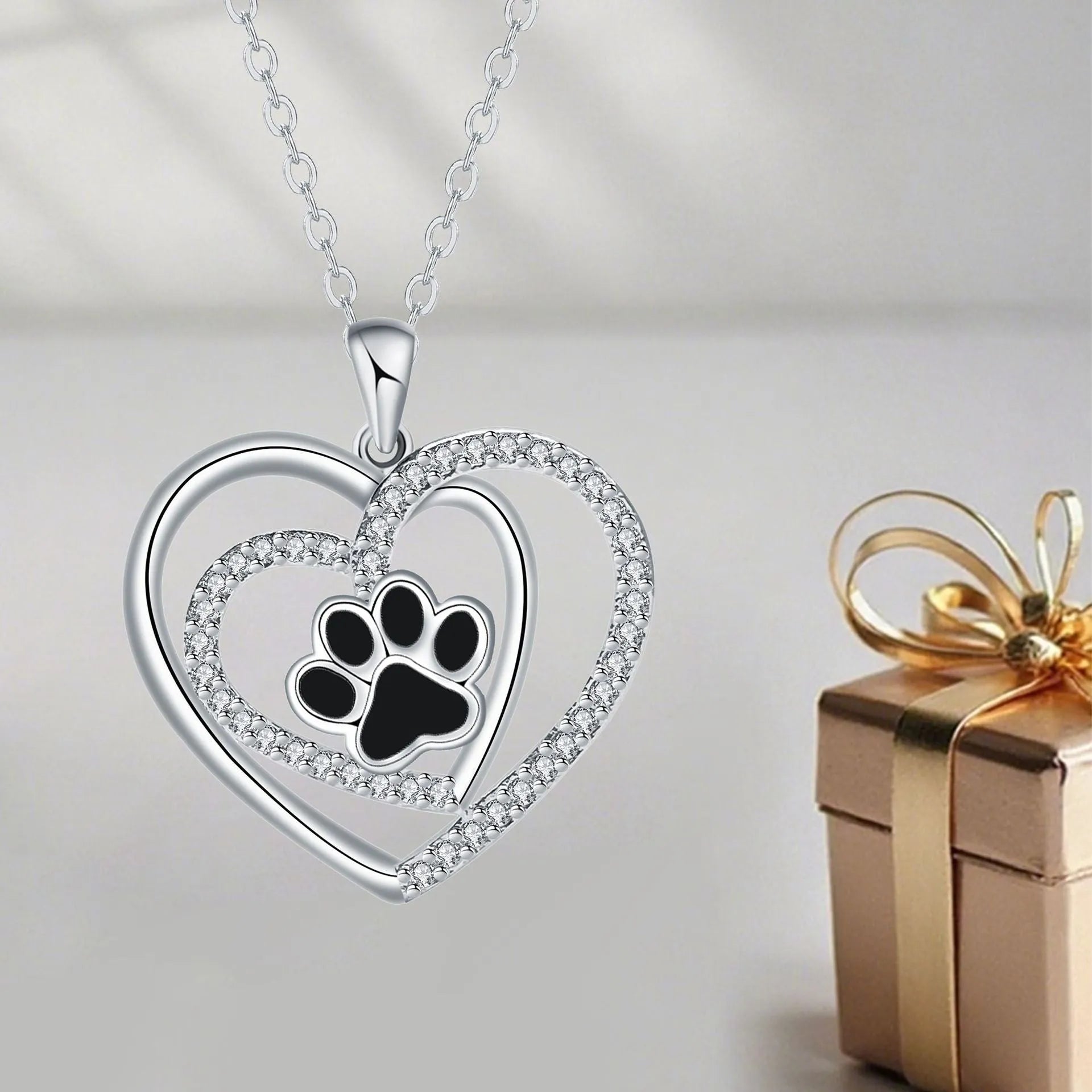 Close-up of a heart-shaped copper necklace pendant featuring a detailed dog's paw print design on a cross chain.