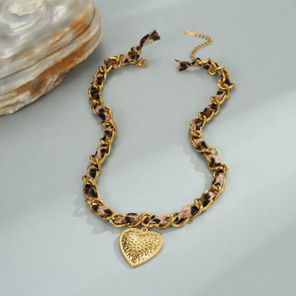 Gold plated leopard print stainless steel necklace with big heart or love sun pendant on a chain.
