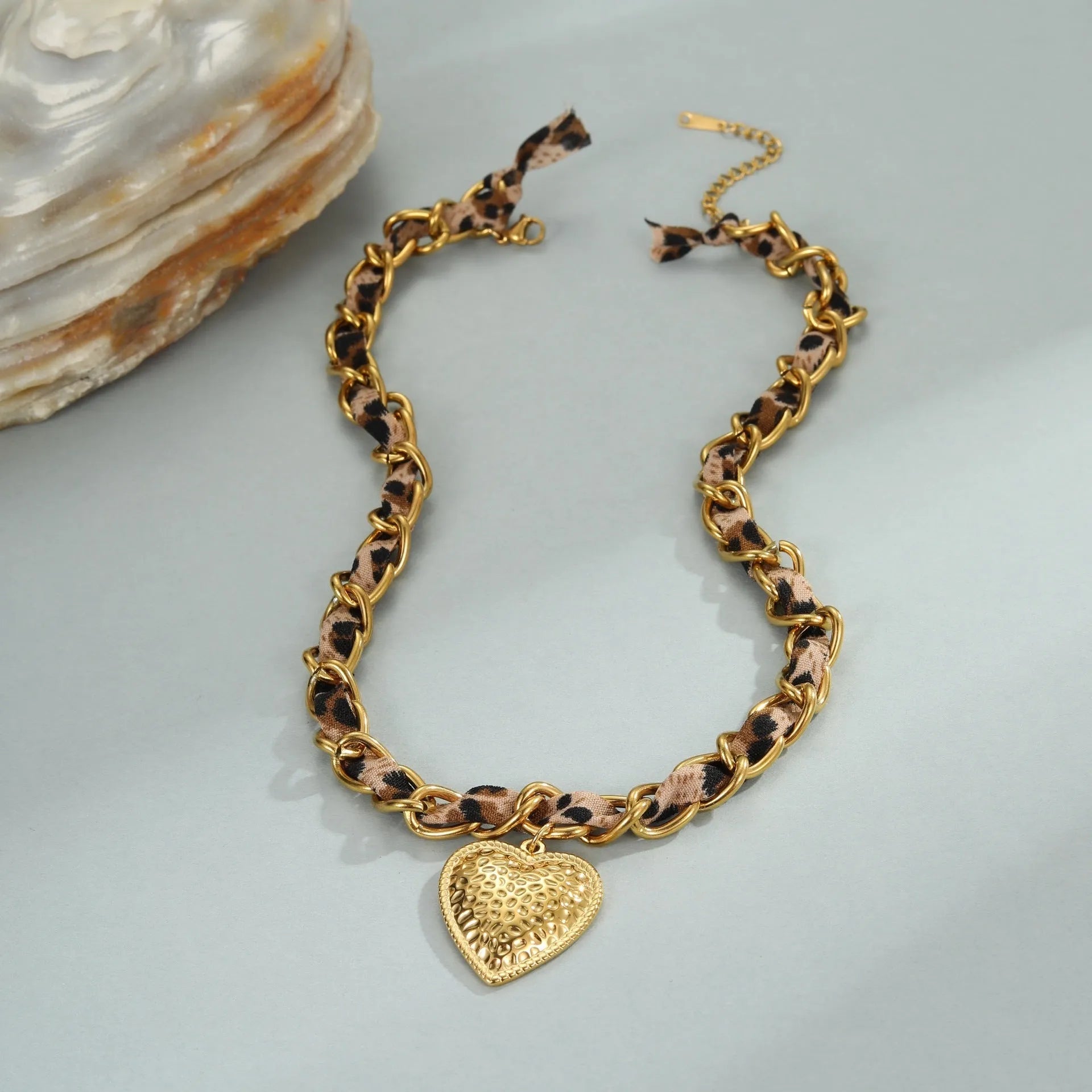 Gold plated leopard print stainless steel necklace with big heart or love sun pendant on a chain.
