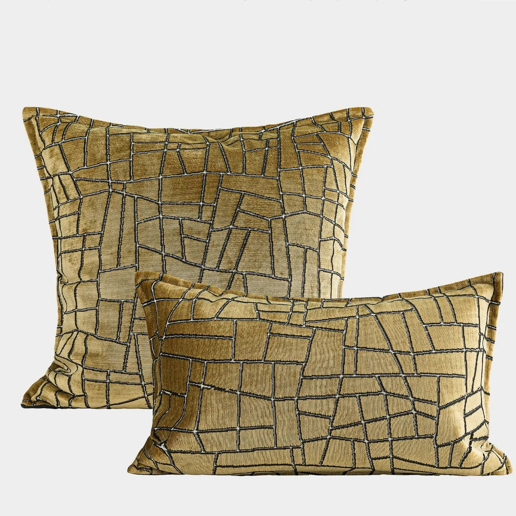 Gold geometric pattern polyester pillow cover shown in square and waist pillow sizes on a grey sofa.