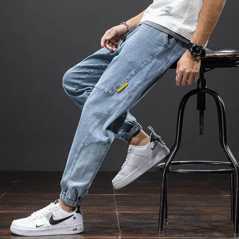 Man wearing grey-blue straight leg cargo jeans with micro elasticity and cargo pockets.