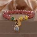 Red women's bracelet with natural strawberry quartz beads, alloy metal chain, and rhinestone details.