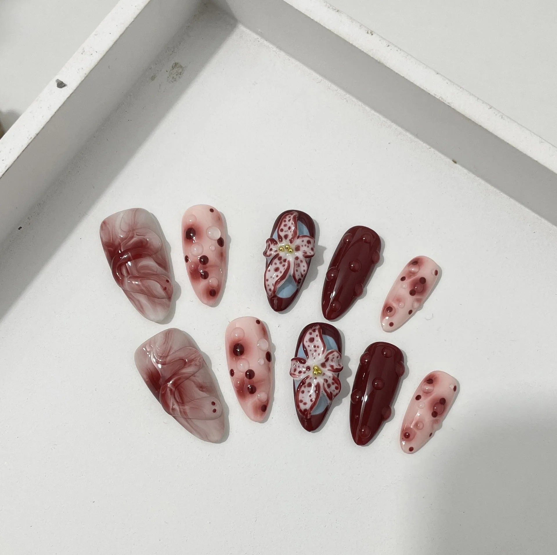 Hand-painted three-dimensional carved artificial nails in almond shape with floral and geometric patterns