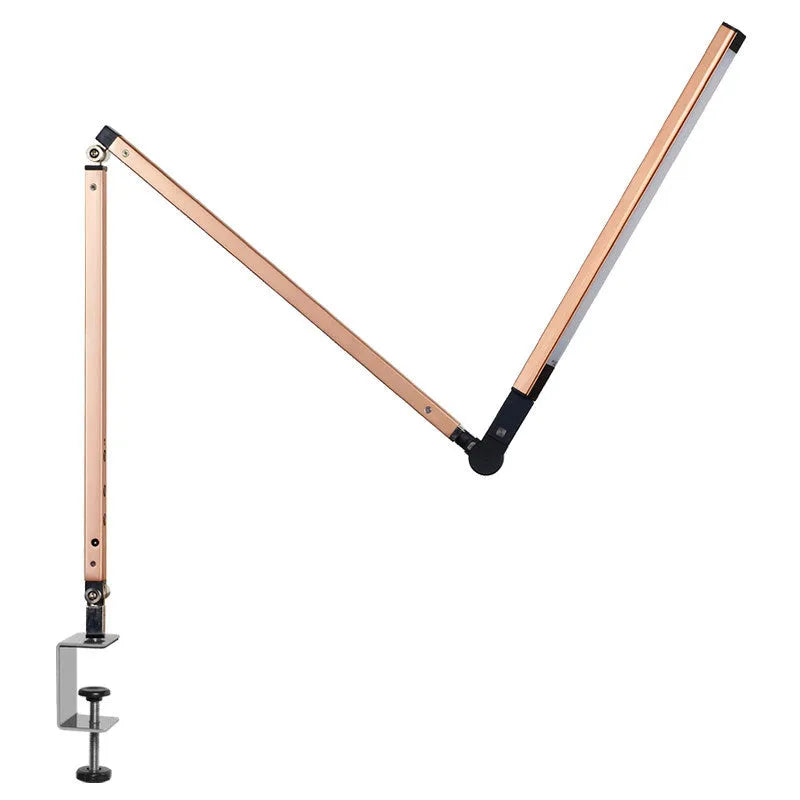 Aluminium LED desk lamp with clip base and remote control on a wooden desk.