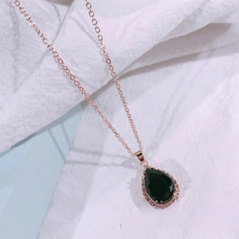 Women's geometric drop shape pendant necklace with rhinestone detail in pink electroplated finish.