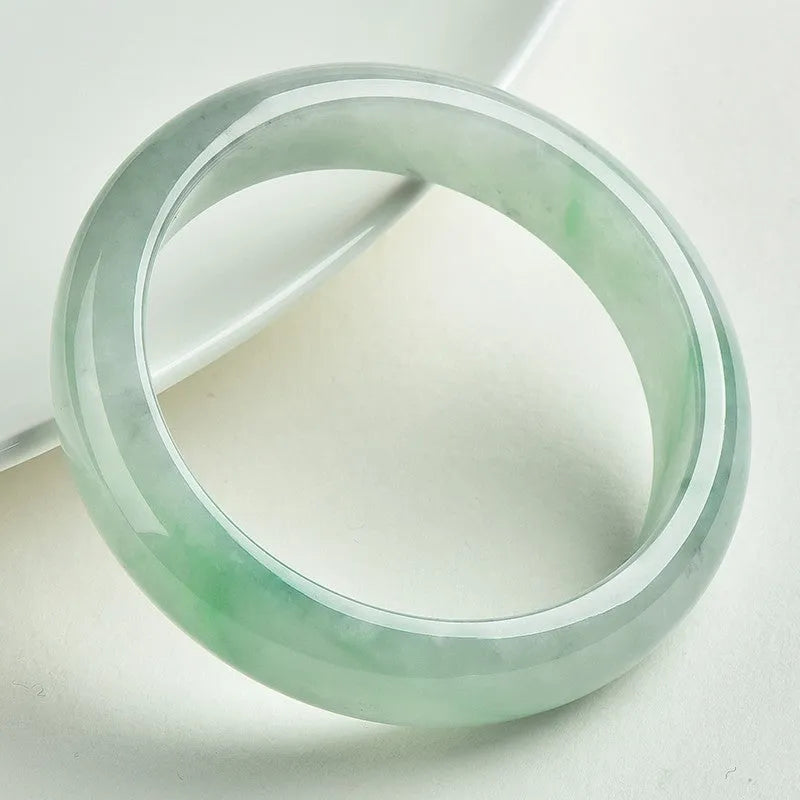 Light green jade bracelet with smooth surface showing natural stone texture