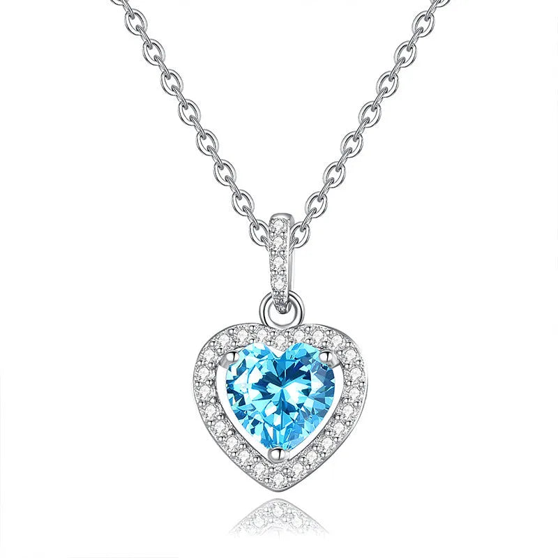 Close-up of a sterling silver heart pendant necklace with an inlaid amethyst gemstone on a cross chain.