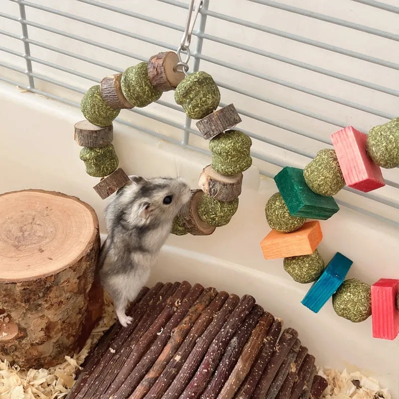 Hamster chew toy with Applewood stick and woven straw ball ring on a white background.