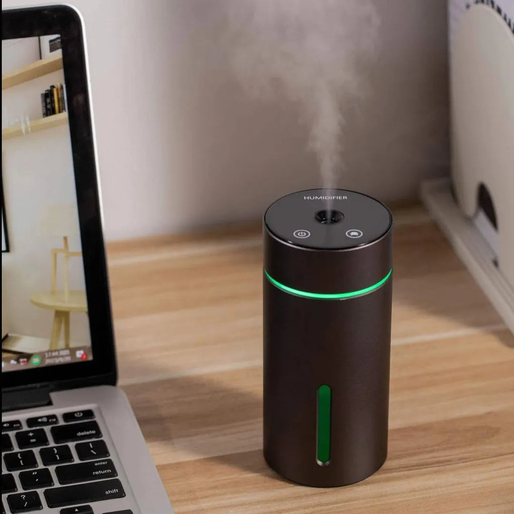 Aluminium portable car air humidifier and essential oil diffuser with multi-colour light on a black USB cable.