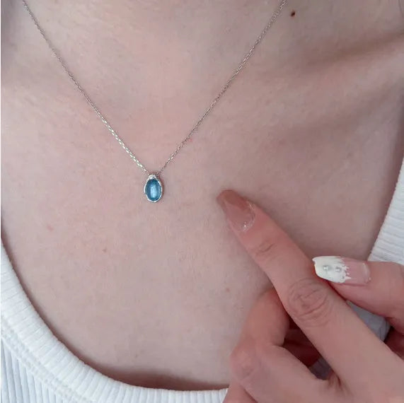 Navy blue water drop pendant necklace with adjustable chain on neutral background