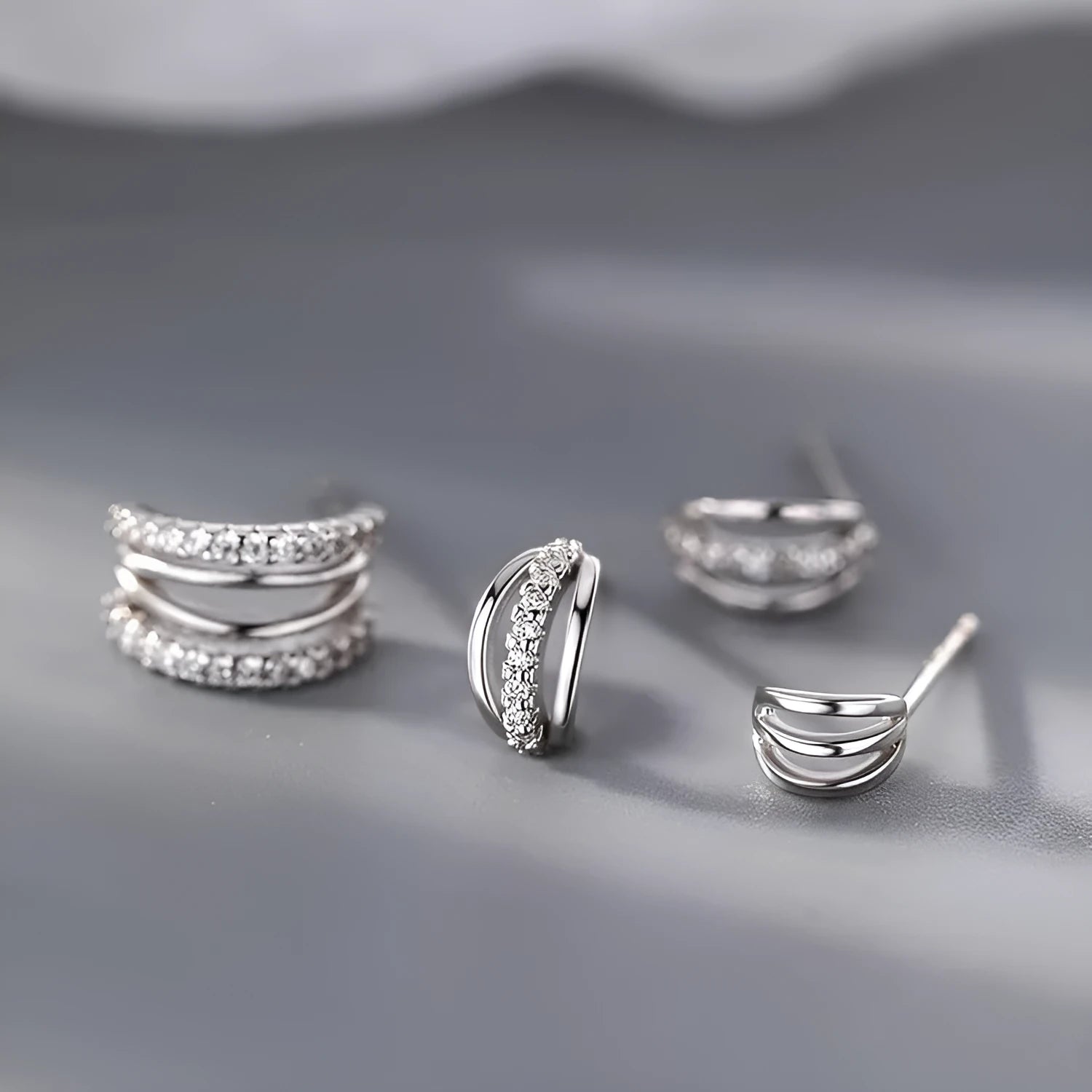 A pair of geometric-shaped 925 silver earrings with an electroplated finish, shown in large, medium, and small size options.