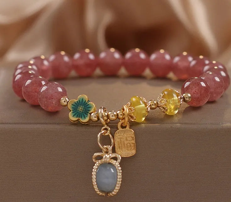 Red women's bracelet with natural strawberry quartz beads, alloy metal chain, and rhinestone details.