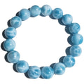 Blue handcrafted bodhi bracelet with sea-pattern crystal stones and pearl accents on a neutral background.