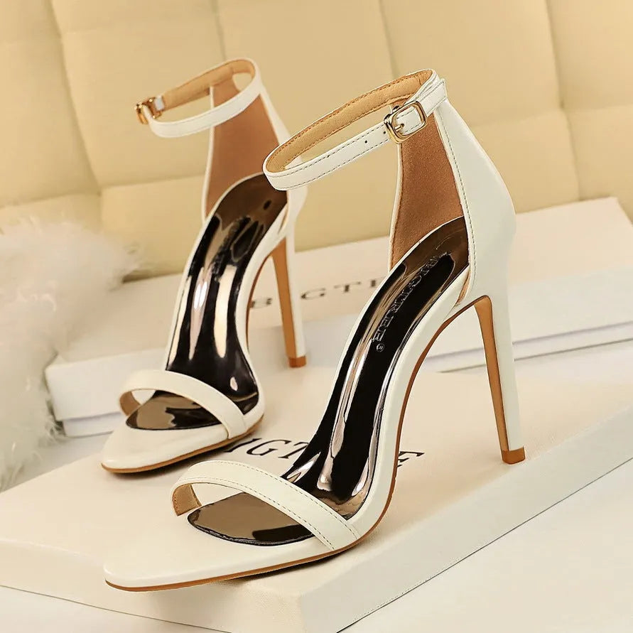 Ankle-strap high heel shoe with open toe and buckle, shown in a solid colour.