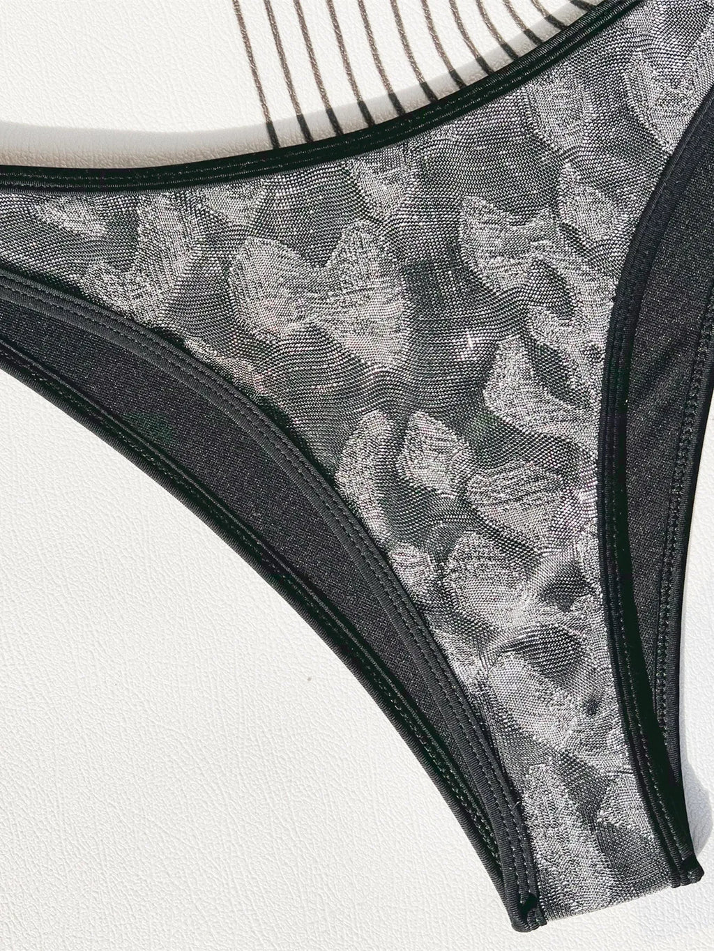 Black women's polyester bikini swimsuit with adjustable straps laid flat.