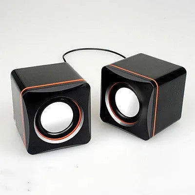 Black square USB-powered 2.0 mini desktop computer speakers on a desk