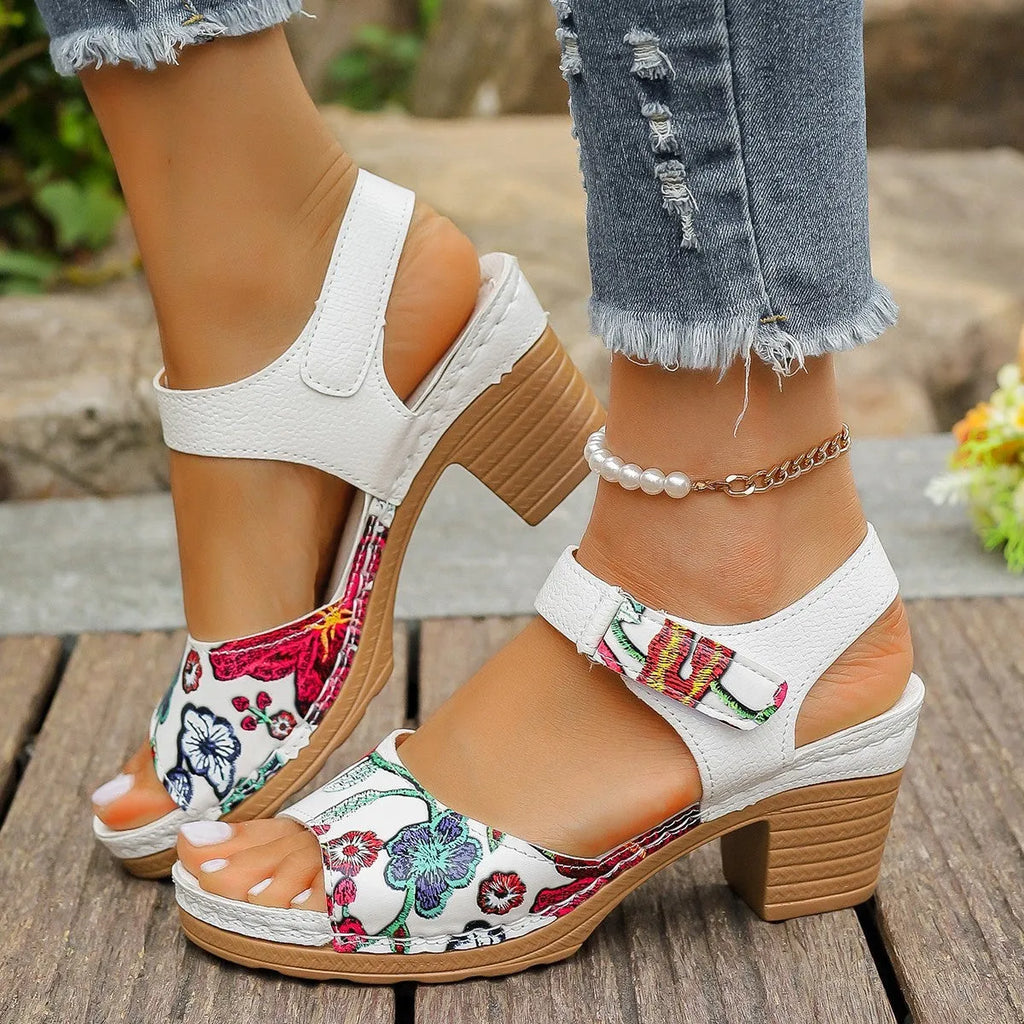 White women's high heel sandals with a Velcro strap buckle on a rubber sole.