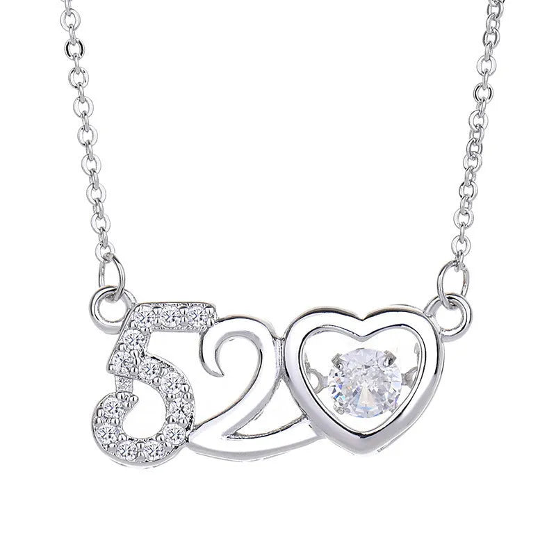 Close-up of a women's silver heart necklace pendant featuring a crown and bow design on a chain.