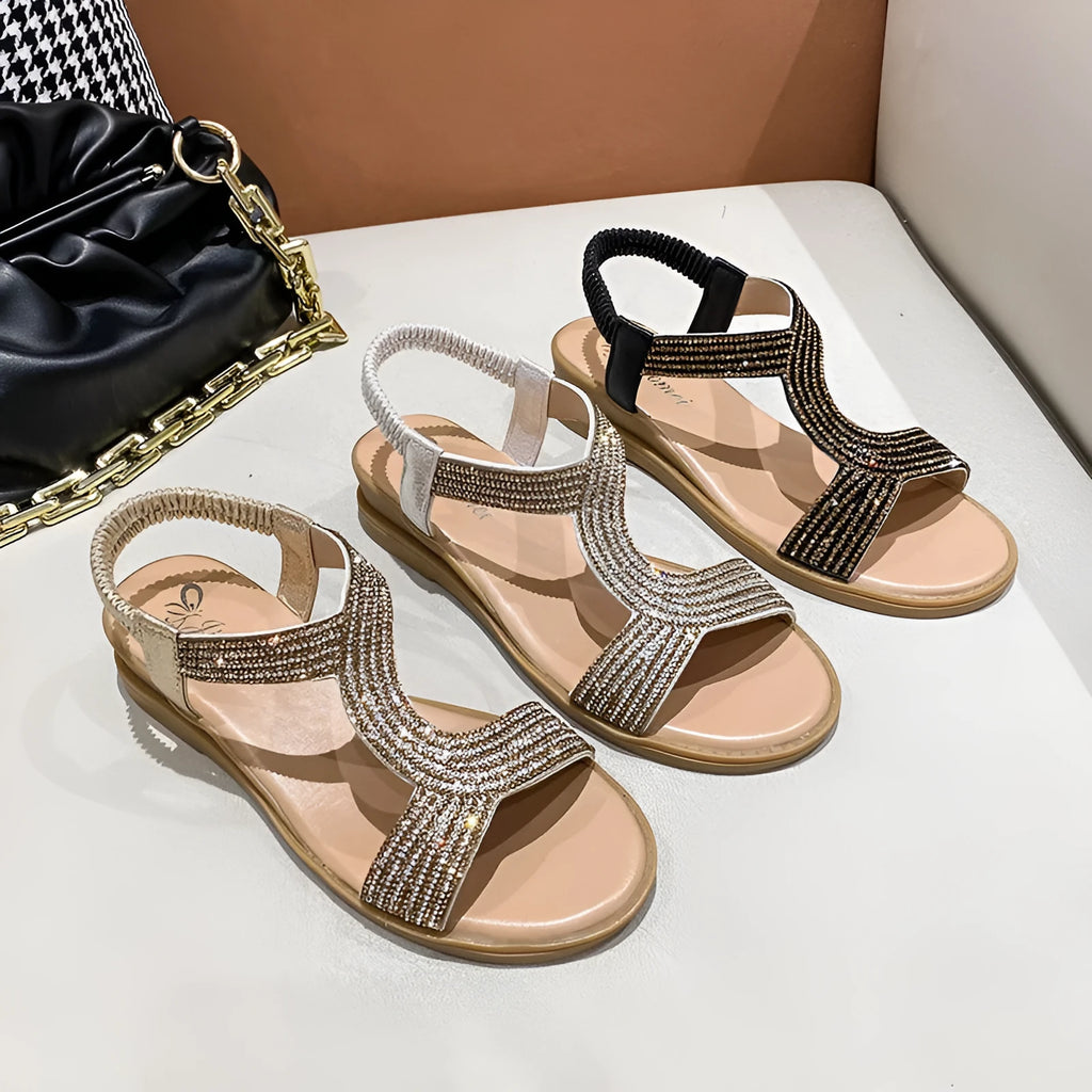 Gold women's patent leather sandals with rhinestone decoration on the strap and a non-slip sole.