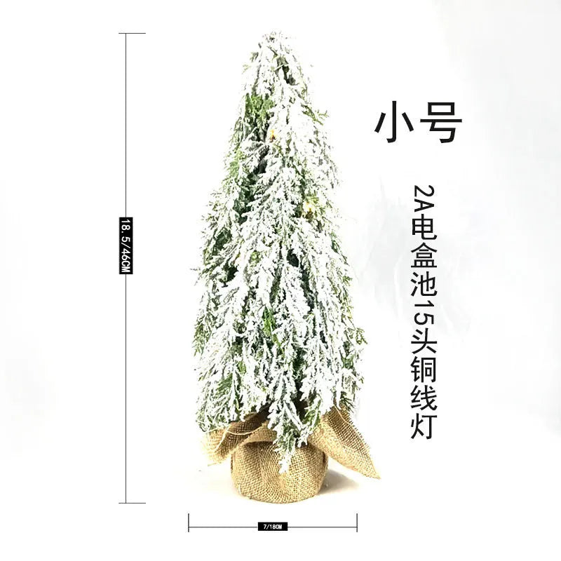 Small 24-inch artificial Christmas tree with snow-spray branches and built-in lights for desktop decoration
