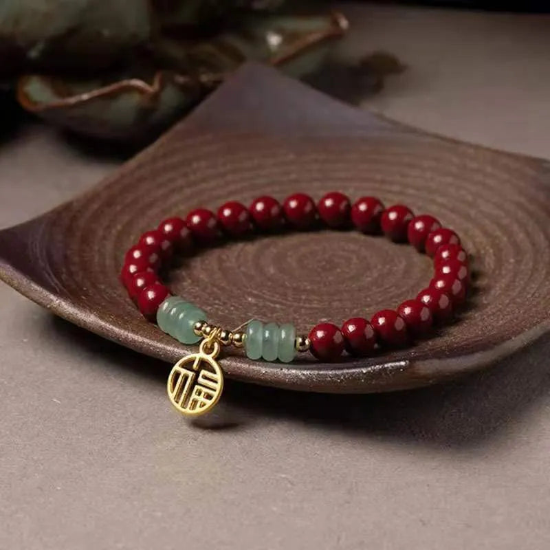 Handmade wave-shaped bracelet in cinnabar and copper beads on a wrist.