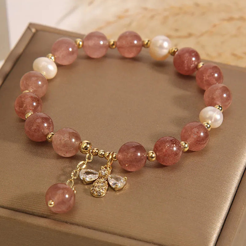 Women's freshwater pearl and strawberry quartz bracelet with zircon accents on wrist