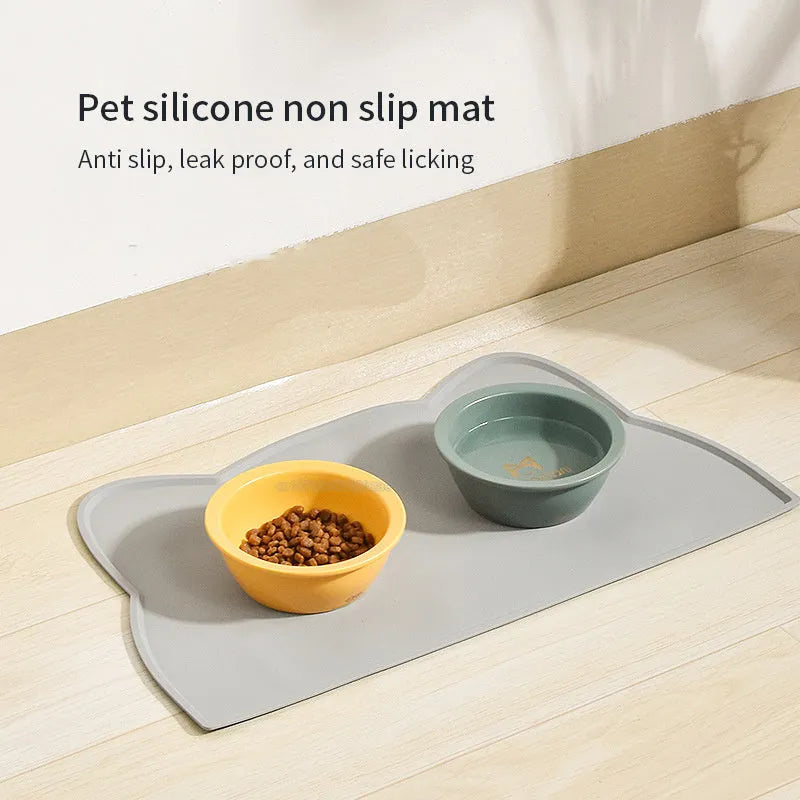 Blue silicone pet feeding mat under food and water bowls measuring 44 by 24 centimetres