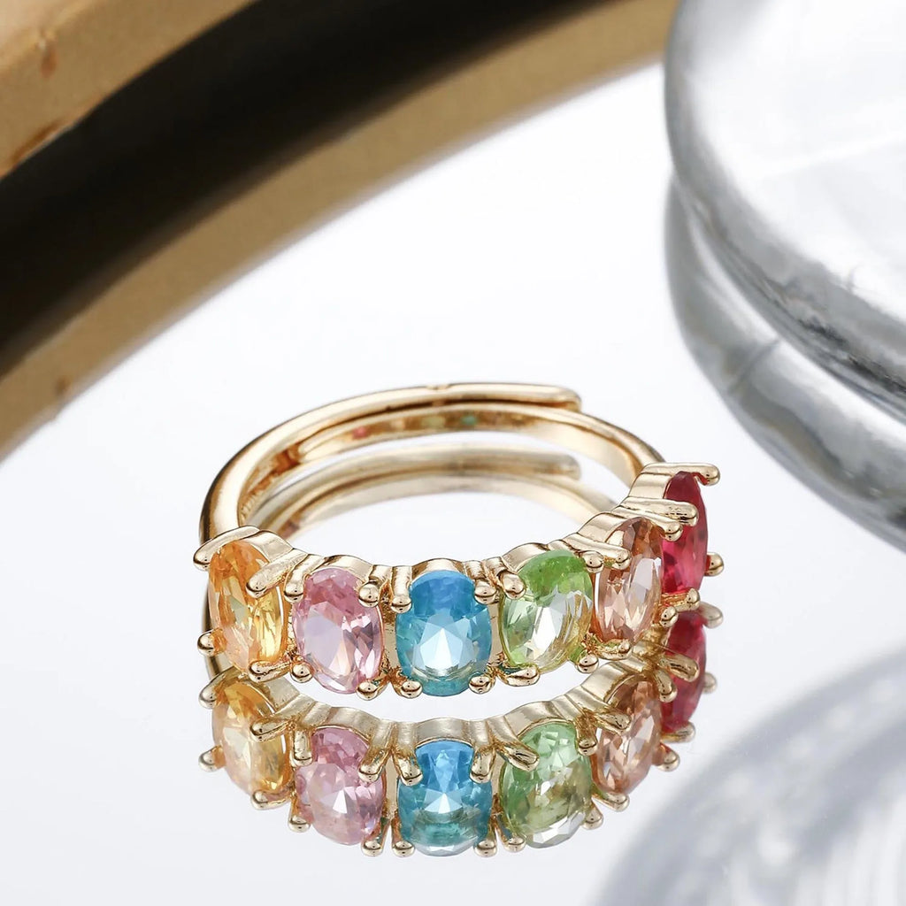 Gold coloured adjustable ring with zircon detail on a white background.
