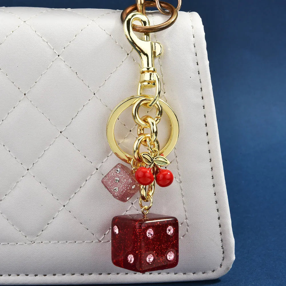 Square metal keychain pendant with cherry two-tone dice pattern and electroplated finish