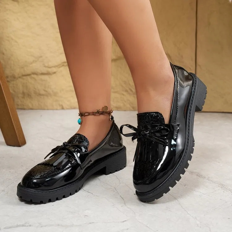 Women's brown loafer shoe with a decorative bow on the artificial PU upper.