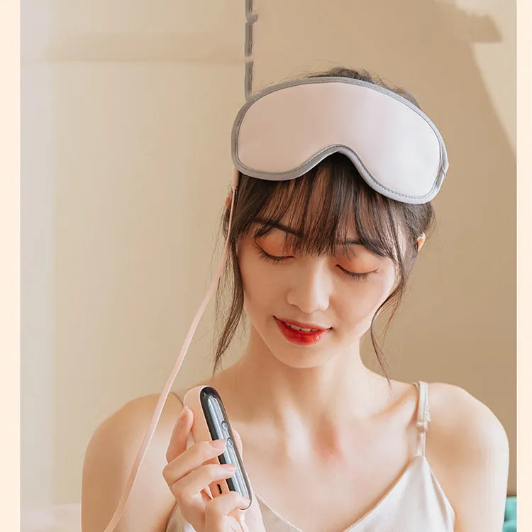 Pink and green portable eye spa mask with USB cable for steam heat and vibration massage.