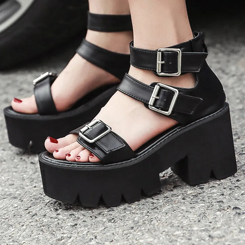 Black women's punk-style chunky heel platform sandals with round toe and buckle detail.