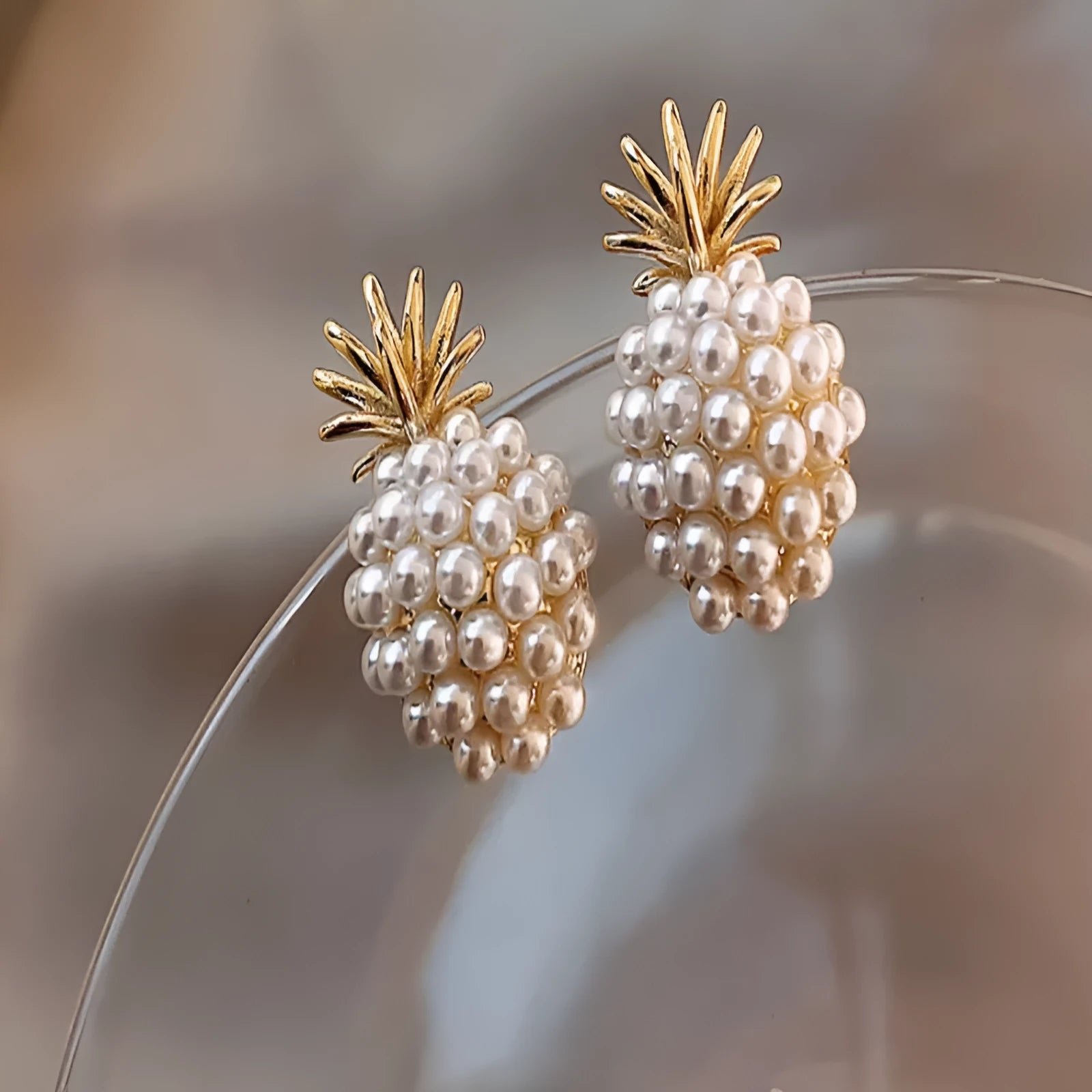 Pineapple and starfish motif drop earrings with pearl and artificial gemstone details on alloy metal